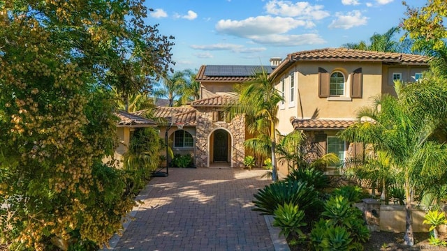 mediterranean / spanish house featuring solar panels