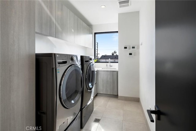 laundry room featuring washer and clothes dryer, sink, and light tile patterned floors