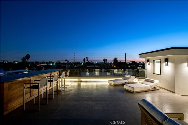 patio terrace at dusk featuring a bar