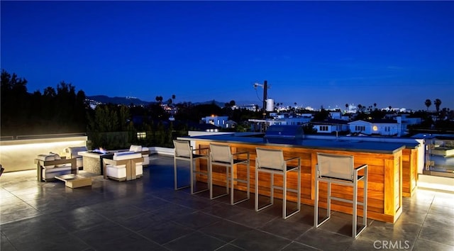 patio at twilight featuring an outdoor bar