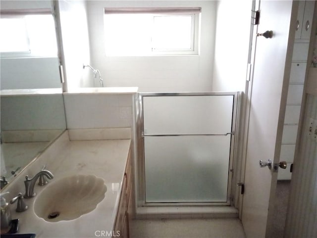 bathroom featuring an enclosed shower, a healthy amount of sunlight, and vanity