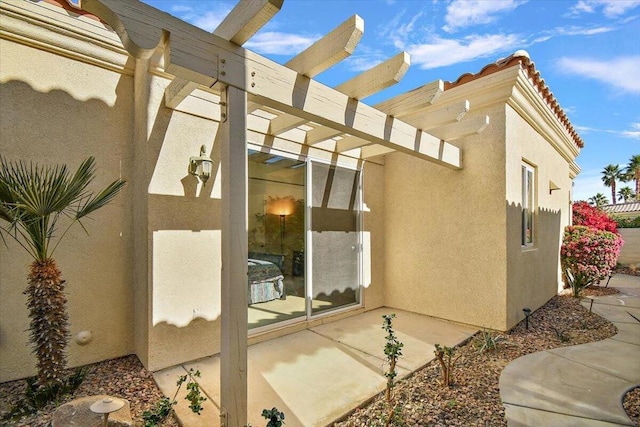 view of property exterior featuring a pergola and a patio