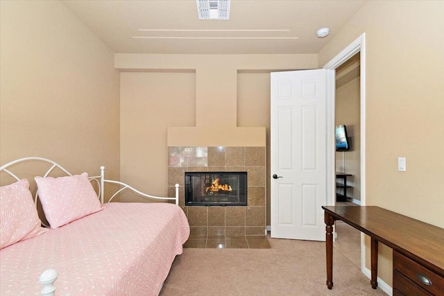 bedroom featuring carpet floors and a tiled fireplace