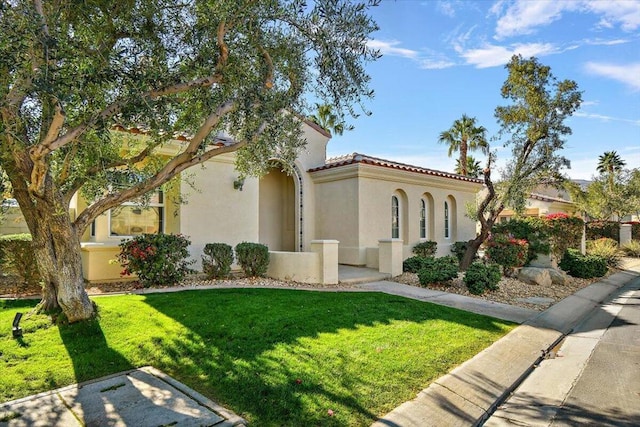 mediterranean / spanish-style house featuring a front yard