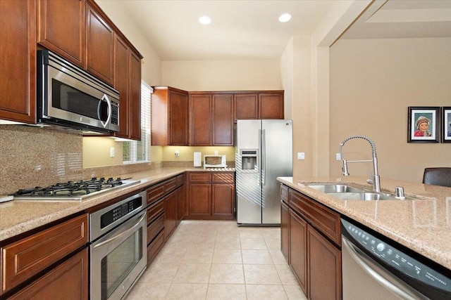 kitchen featuring tasteful backsplash, sink, light tile patterned flooring, light stone countertops, and stainless steel appliances