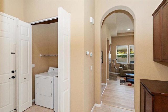 clothes washing area with light tile patterned flooring and washer / clothes dryer