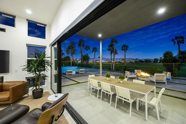 patio terrace at dusk featuring an outdoor living space with a fire pit