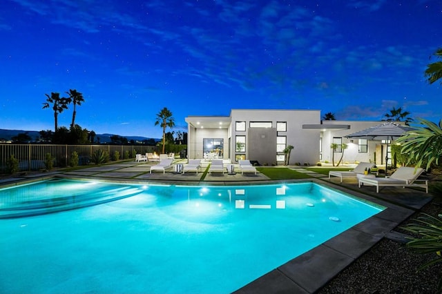 pool at dusk featuring a patio area