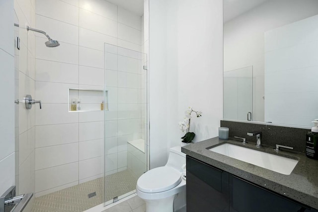 bathroom with tile patterned flooring, vanity, an enclosed shower, and toilet