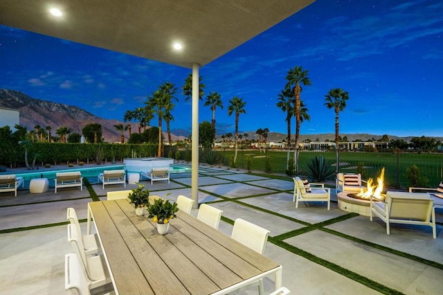 view of patio / terrace with an outdoor fire pit and a mountain view