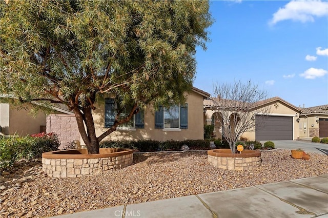 view of front of property with a tile roof, driveway, an attached garage, and stucco siding