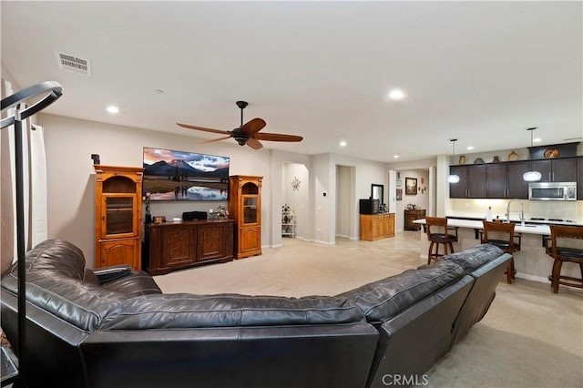 living room featuring baseboards, visible vents, a ceiling fan, light colored carpet, and recessed lighting