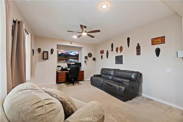 living room with baseboards, a ceiling fan, and light colored carpet