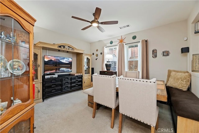 dining space with visible vents, a ceiling fan, and light colored carpet