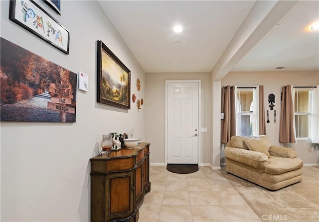 foyer entrance with light tile patterned flooring, visible vents, and baseboards