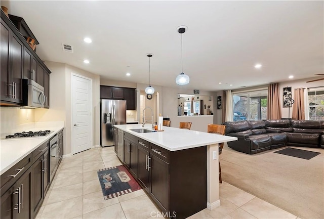 kitchen featuring recessed lighting, visible vents, appliances with stainless steel finishes, open floor plan, and a sink