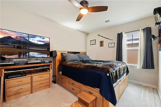 bedroom with light carpet, ceiling fan, visible vents, and baseboards