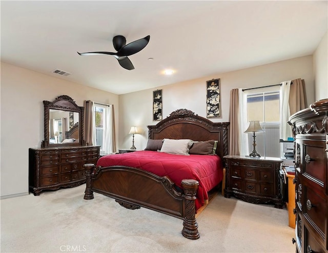 bedroom with light carpet, multiple windows, visible vents, and a ceiling fan