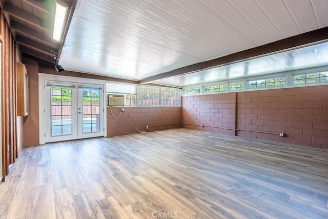 unfurnished sunroom with beamed ceiling and french doors