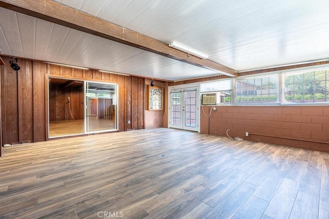 interior space featuring french doors, beam ceiling, cooling unit, and hardwood / wood-style flooring