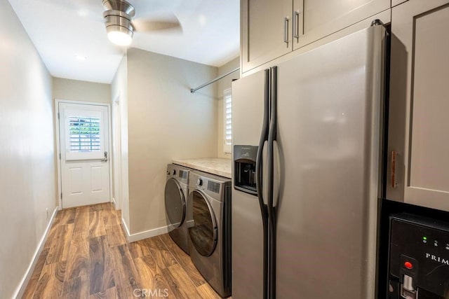 clothes washing area with cabinets, dark hardwood / wood-style floors, washing machine and clothes dryer, and ceiling fan