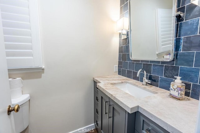 bathroom with tasteful backsplash, vanity, and toilet