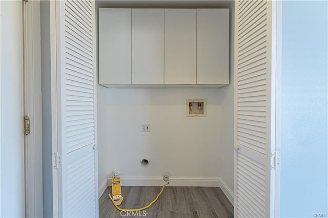 laundry room with dark wood-type flooring, electric dryer hookup, hookup for a washing machine, and cabinets