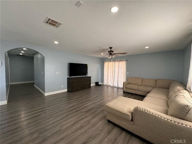 unfurnished living room featuring ceiling fan and dark wood-type flooring