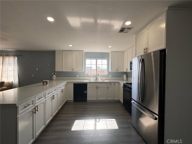 kitchen featuring black appliances, kitchen peninsula, sink, and white cabinetry