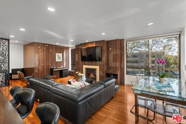 living room with light wood-type flooring and a large fireplace