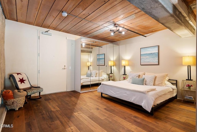 bedroom featuring beam ceiling, wood ceiling, and hardwood / wood-style flooring