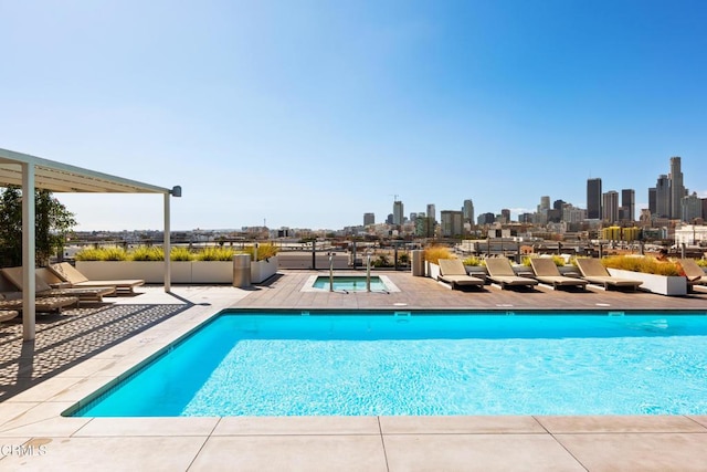 view of swimming pool featuring a community hot tub and a patio