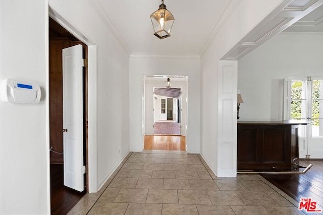 hallway featuring crown molding and light tile patterned floors