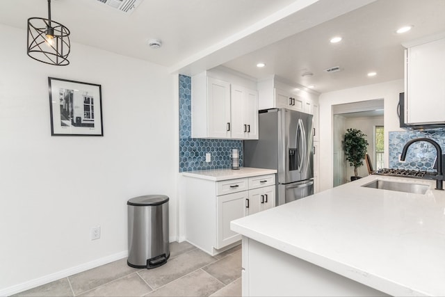 kitchen with white cabinets, stainless steel refrigerator with ice dispenser, tasteful backsplash, sink, and hanging light fixtures