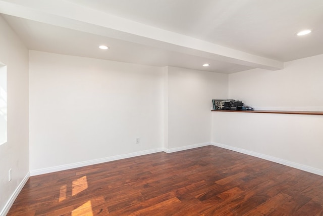 empty room featuring beam ceiling and dark hardwood / wood-style floors