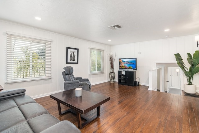 living room with a textured ceiling, dark hardwood / wood-style flooring, and crown molding