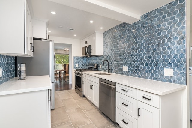 kitchen featuring appliances with stainless steel finishes, decorative backsplash, white cabinets, and sink