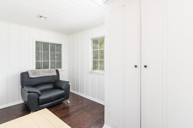 living area with dark hardwood / wood-style floors, wood ceiling, and crown molding