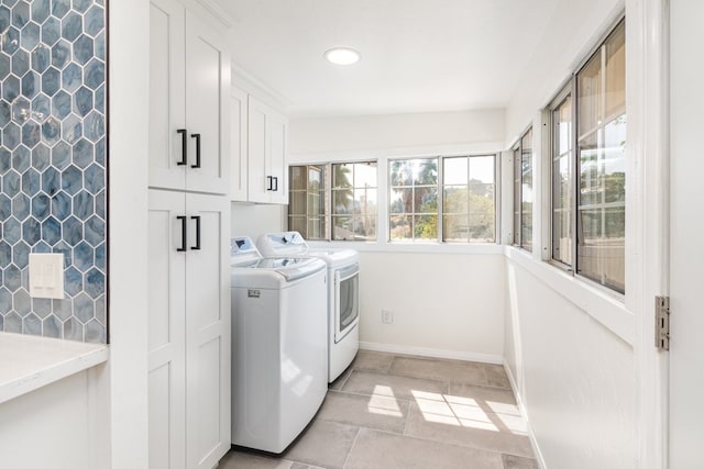 laundry room featuring cabinets, light tile patterned floors, and washer and clothes dryer