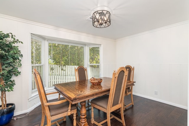 dining room with dark wood-type flooring, a chandelier, and crown molding