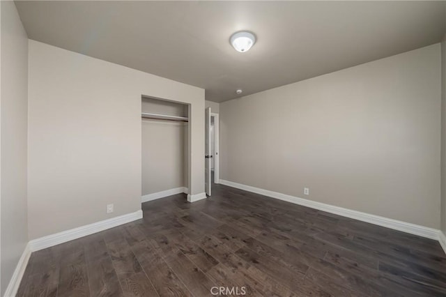 unfurnished bedroom with dark wood-type flooring and a closet