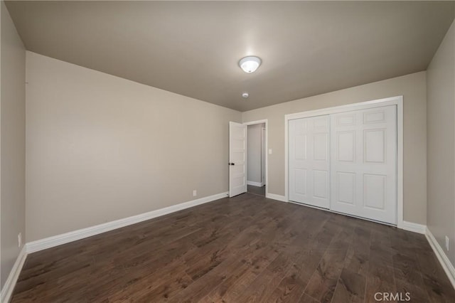 unfurnished bedroom featuring a closet and dark hardwood / wood-style flooring