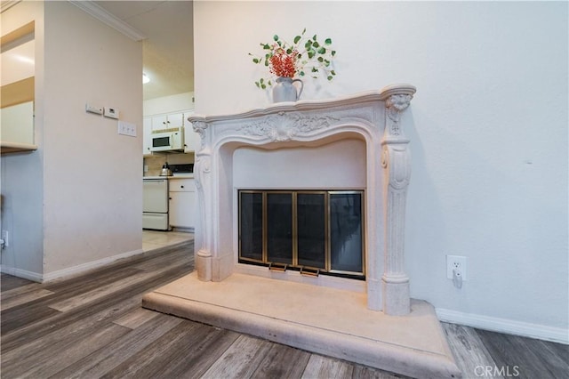 details with hardwood / wood-style flooring, range, crown molding, and a premium fireplace