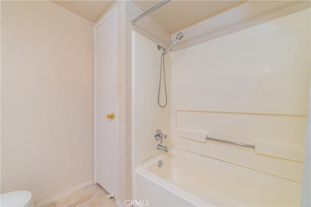 bathroom featuring shower / bathing tub combination, tile patterned flooring, and toilet