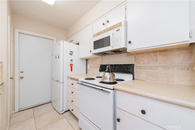 kitchen featuring light tile patterned floors, white cabinets, tasteful backsplash, and white appliances