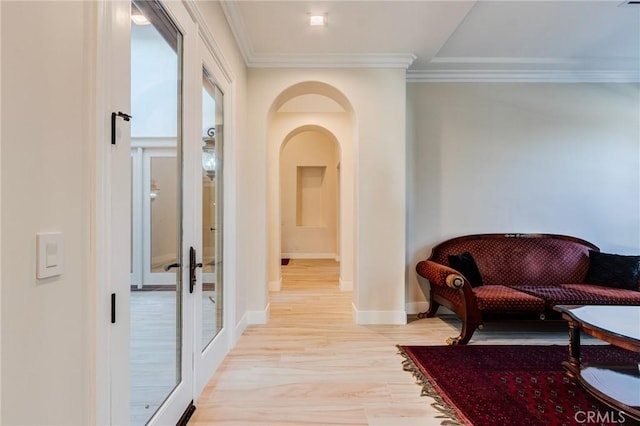 hallway with light wood-type flooring, french doors, and crown molding