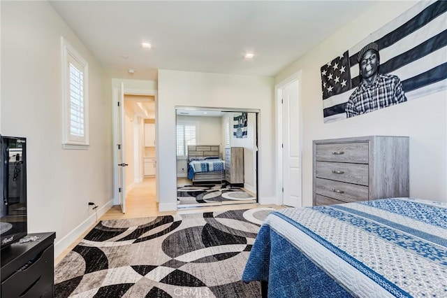 bedroom featuring multiple windows and light hardwood / wood-style flooring