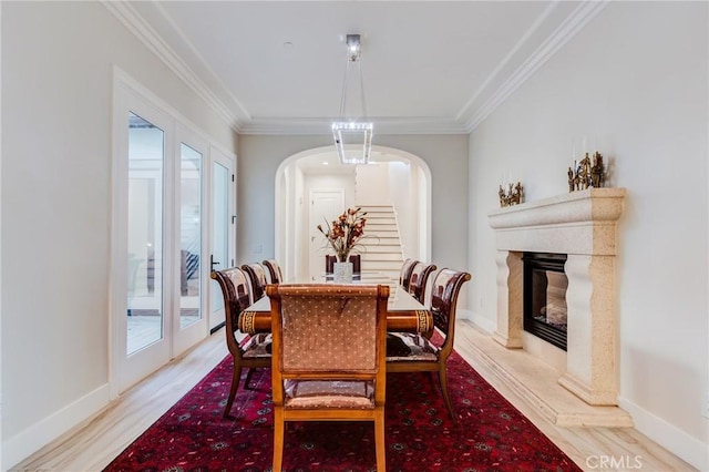 dining area featuring a premium fireplace, ornamental molding, and plenty of natural light