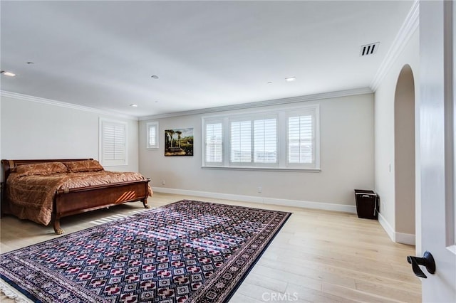 bedroom with ornamental molding and light hardwood / wood-style floors