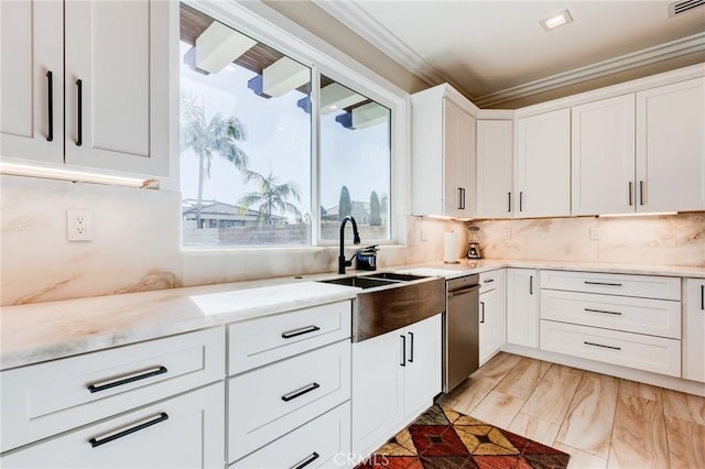 kitchen with light stone countertops, ornamental molding, sink, white cabinetry, and backsplash